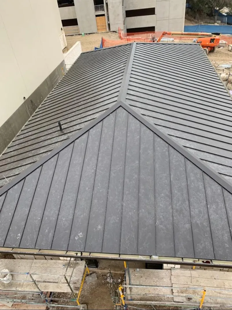 Commercial metal roof construction with crane equipment in Cloverly